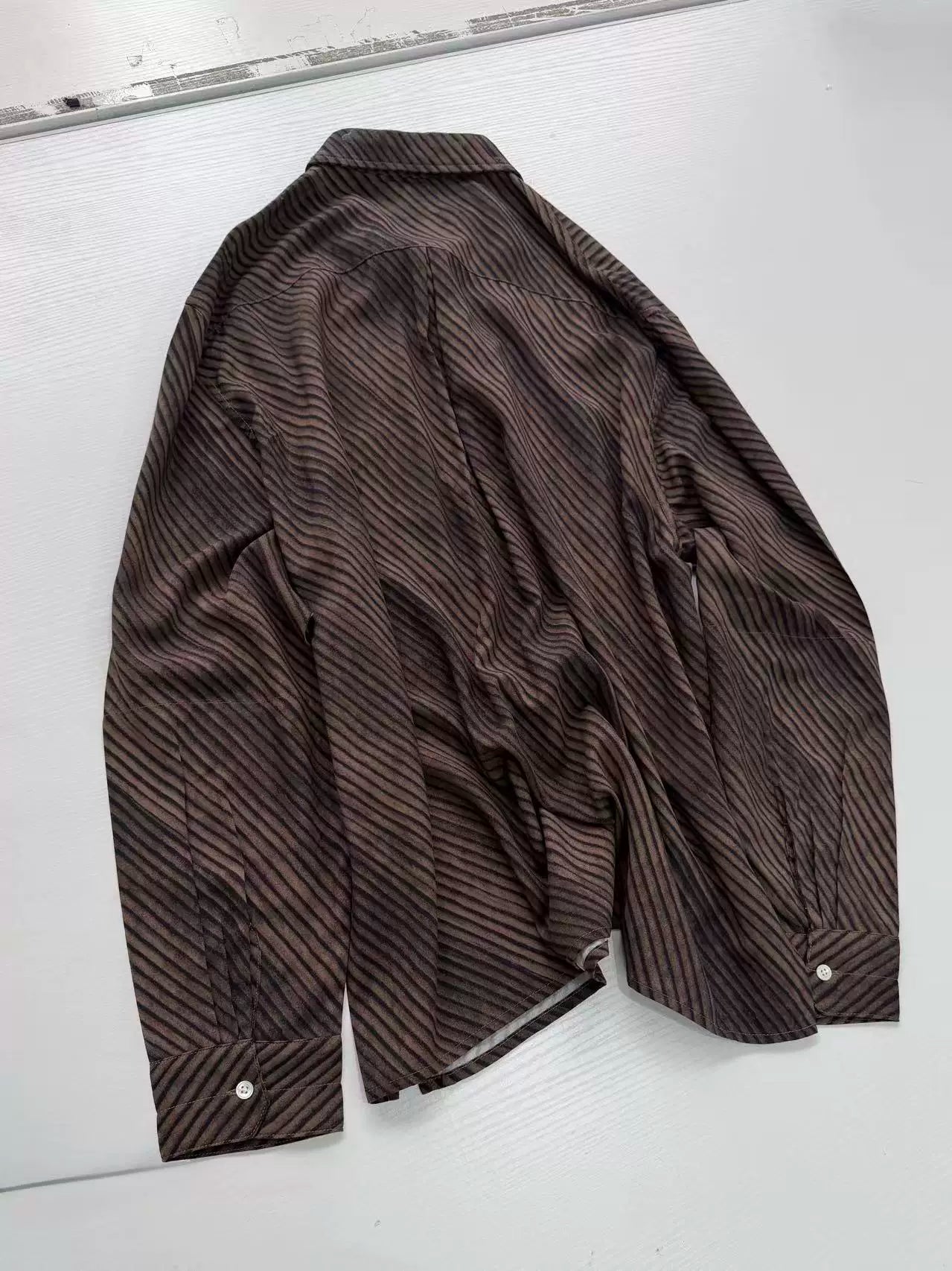 Umber wave-stripe fluid shirt — flat lay, back