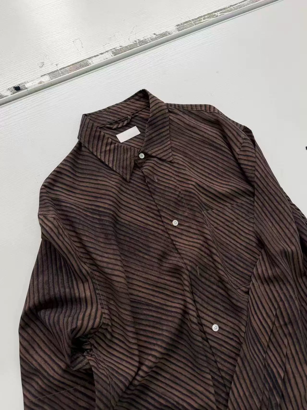 Umber wave-stripe fluid shirt — flat lay, front