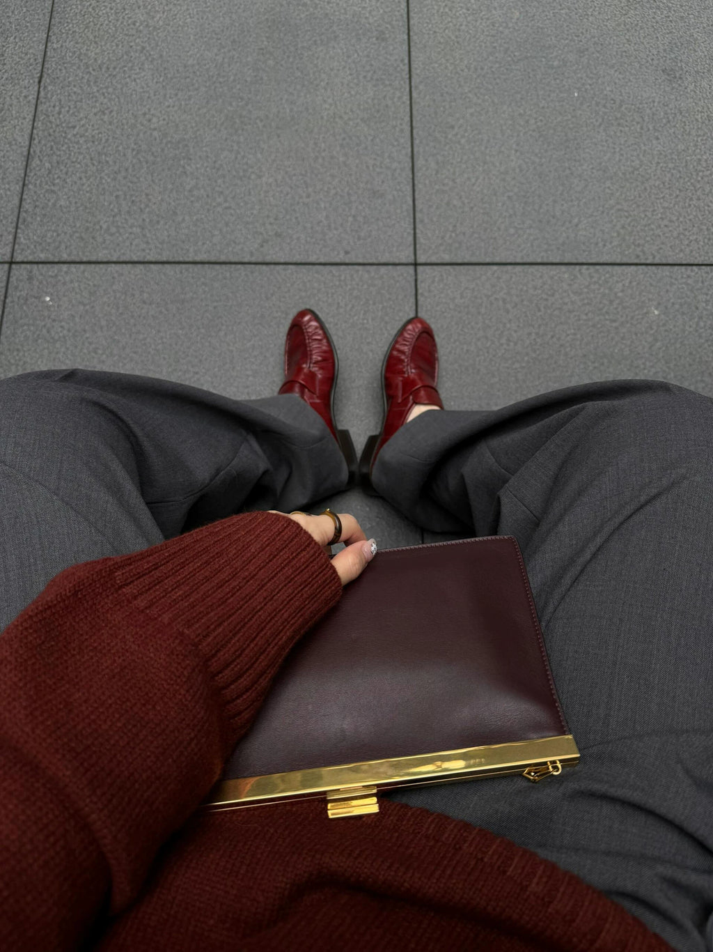 Bordeaux ruched eel leather loafers — styled on feet with grey trousers